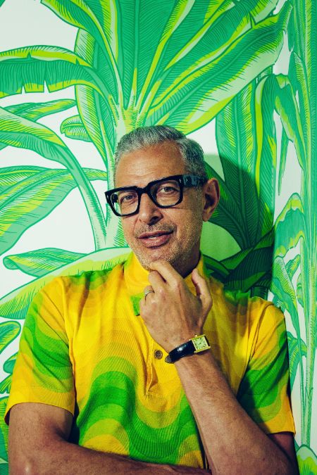 Jeff Goldblum in a yellow-green t-shirt poses for a picture.